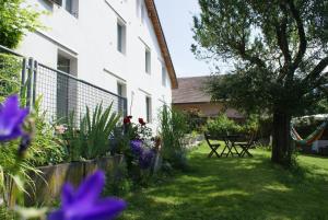 einen Garten mit einem Tisch und Blumen vor einem Gebäude in der Unterkunft Carpe Diem - Bnb - Chambres d'hôtes in Péry