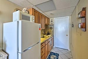 a kitchen with a white refrigerator and wooden cabinets at Condo with Pool Access on Wildwood Crest Beach! in Wildwood Crest