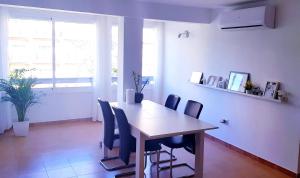a dining room with a wooden table and chairs at Apartamento La Carihuela in Torremolinos +7 photos