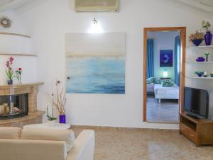a living room with a fireplace and a television at Georgia Villas in Skiathos