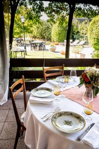 una mesa con platos y copas de vino. en Albergo Cerchi, en Tortona