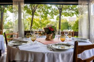 una mesa con mantel blanco y copas de vino en Albergo Cerchi, en Tortona