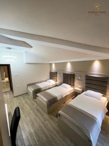 ein Hotelzimmer mit 3 Betten in der Unterkunft Hotel Holiday in Podgorica