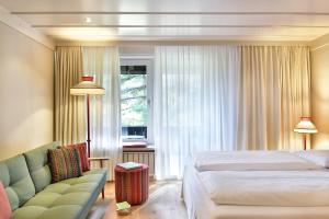 una camera da letto con un letto, un divano e una finestra di Ansitz Punthof a Lagundo