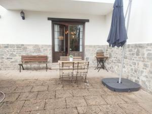 un patio con mesa, sombrilla y banco en Mirador de Leres, en Jaca