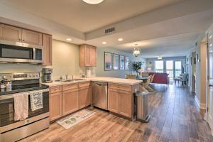 a kitchen with wooden cabinets and stainless steel appliances at Beachfront Nags Head Condo with Private Balcony! in Nags Head