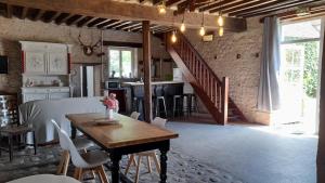 a kitchen and dining room with a table and a staircase at La Ferme de l'isle et sa Roulotte in Avaray