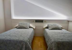 dos camas sentadas una al lado de la otra en una habitación en Duplex Playa Langosteira en Finisterre