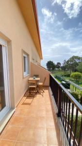 un balcón de una casa con mesa y sillas en Duplex Playa Langosteira en Finisterre