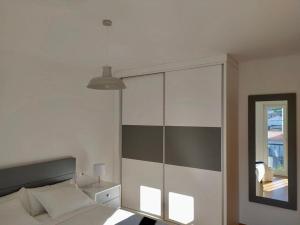 1 dormitorio con cama y espejo en Duplex Playa Langosteira en Finisterre