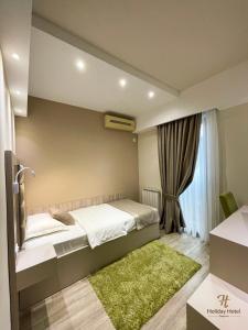 a bedroom with a bed and a large window at Hotel Holiday in Podgorica
