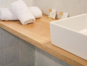 a counter with white towels on a wooden shelf at Georgia Villas in Skiathos