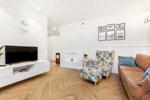 a living room with a couch and a tv at Holiday Sopot Apartment in Sopot