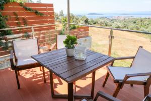 a wooden table and chairs on a deck with a view at Georgia Villas in Skiathos