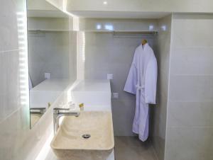 a bathroom with a sink and a robe on a wall at Georgia Villas in Skiathos