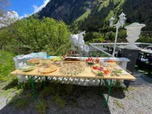 una mesa con comida delante de una montaña en Boxenstopp Gurtnellen en Gurtnellen