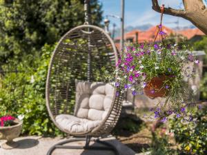 Green Home Apartments في كوتور: كرسي ratan مع الزهور في الحديقة