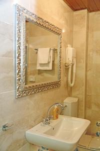 ein Badezimmer mit einem Waschbecken, einem Spiegel und einem WC in der Unterkunft Hotel Marija in Kotor