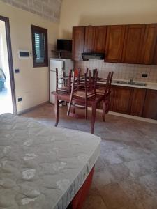 una cucina con un tavolo e sedie in una stanza di Oasi Del Visir Resort a San Vito dei Normanni