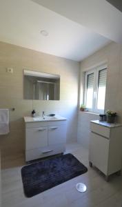 La salle de bains est pourvue d'un lavabo et d'un miroir. dans l'établissement Casa da Avó, à Ponte de Lima