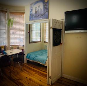 a room with a bed and a television and a table at Two Top Central Unique Artisan Beach Studios - also separate spa cabin in Brighton & Hove