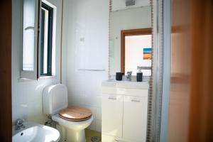a white bathroom with a toilet and a sink at Kichershome in Sagres