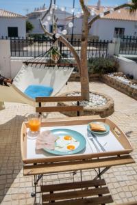 a table with a plate of eggs and bread on it at Kichershome in Sagres
