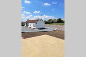 a small white building in the middle of a road at Mary-Jane’s Cottage in Omagh +15 photos