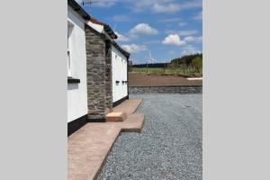 a house with white doors and a gravel driveway at Mary-Jane’s Cottage in Omagh