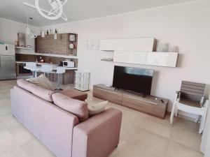 a living room with a couch and a flat screen tv at Villa Zizzari A Due Passi Dal Mare in Torre Lapillo