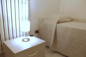 um quarto com uma cama e uma mesa com um candeeiro em Villa Bice em Pulsano