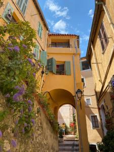 un callejón en la ciudad italiana de cannolis con flores en Vieux Château, en Menton