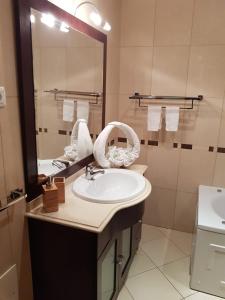 une salle de bains avec un lavabo et un miroir dans l'établissement Jardins de Pera vila M, à Pêra