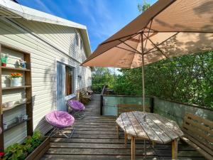 a patio with a table and chairs and an umbrella at Cottage Novak in Salmi