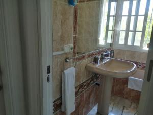 een badkamer met een wastafel en een spiegel bij Room in Lovely cottage house Habitaciones en Chalet en Cadiz San Fernando in San Fernando