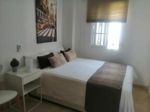 een slaapkamer met een groot wit bed en een raam bij Room in Lovely cottage house Habitaciones en Chalet en Cadiz San Fernando in San Fernando