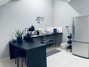 a kitchen with a black counter and a refrigerator at Putrajaya Bangi Minimalist Loft 1 Wifi Netflix in Kajang