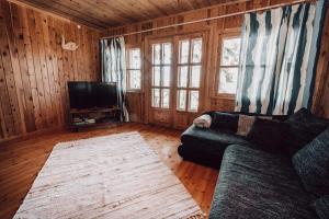 sala de estar con sofá y TV de pantalla plana en Ranniku Holiday House en Rannaküla