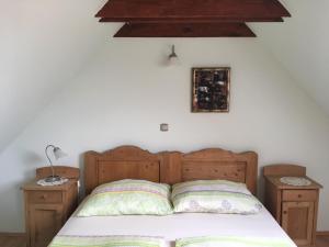 1 dormitorio con 1 cama de madera y 2 mesitas de noche en HoMe Vendégház, en Ganna