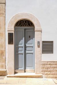 a gray door in a white building with an arch at Continuum 28 in Castellana Grotte