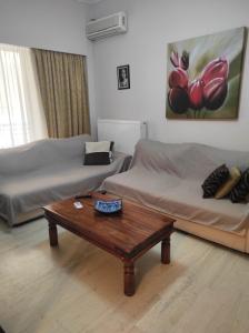 uma sala de estar com 2 camas e uma mesa de centro em Alimos Apartment em Atenas