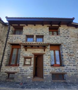 uma casa de pedra com uma porta em frente em Casa Arangol em Pedruel
