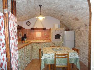 a kitchen with a table and a white refrigerator at La Casa di Petra in Modica