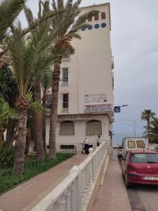 un edificio bianco con palme di fronte di garrucha 100 mts playa, 2 Dorm a Garrucha