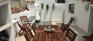 een houten tafel en stoelen op een balkon bij El Enclave in Chulilla