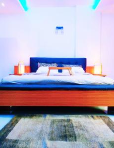 una camera con letto con struttura blu e rossa di L'appartement Alpha Dakar a Dakar