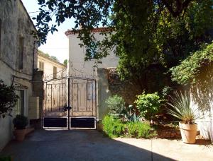 uma entrada para uma casa com um portão de ferro em Le 26 em Nîmes