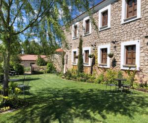 un jardín con sillas y una mesa frente a un edificio en El Cuartel del Rio Dulce, en Mandayona
