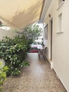 eine Außenterrasse mit Pflanzen und einem Tisch in der Unterkunft Alimos Apartment in Athen