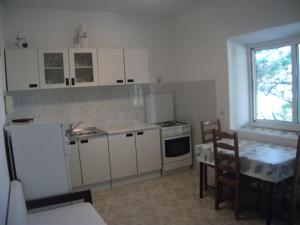 kuchnia z białymi szafkami, stołem i oknem w obiekcie House Lumbarda (876) w mieście Lumbarda +32 zdjęcia